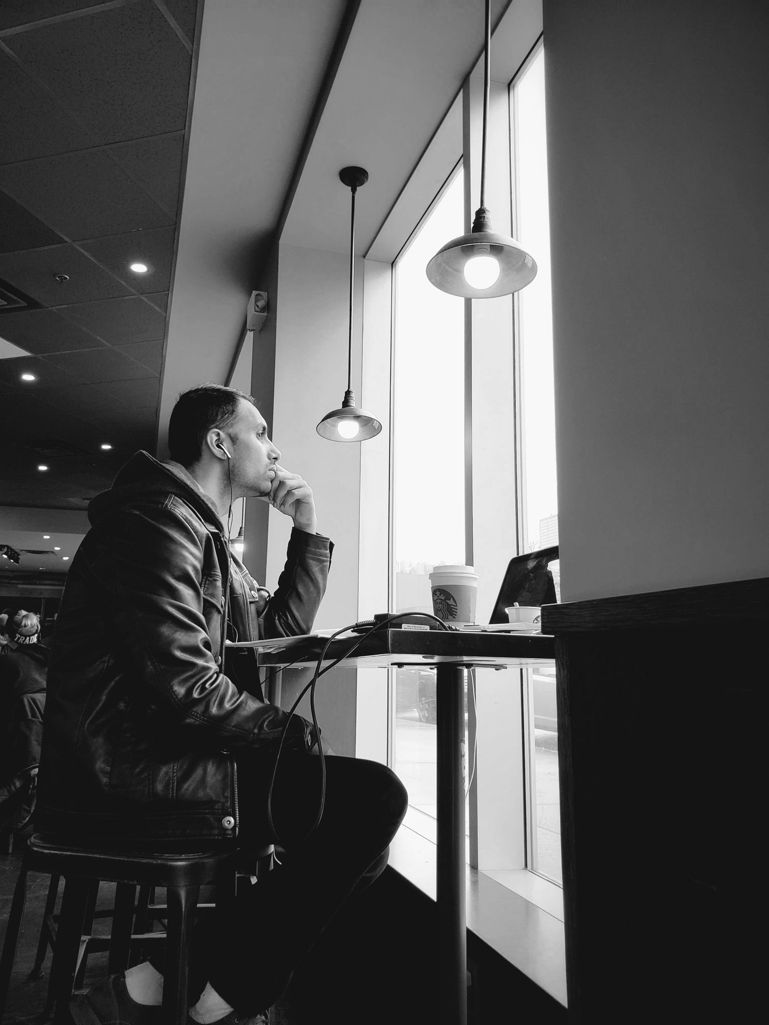 Ahmed at a cafe window, thinking