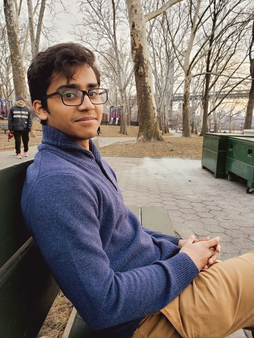 Ahmed Razin sitting on a bench in a New York park